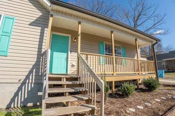 a view of a house with wooden deck and furniture