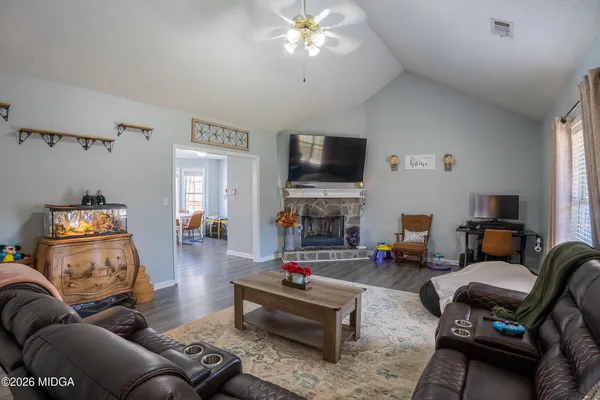 a living room with furniture a fireplace and a flat screen tv