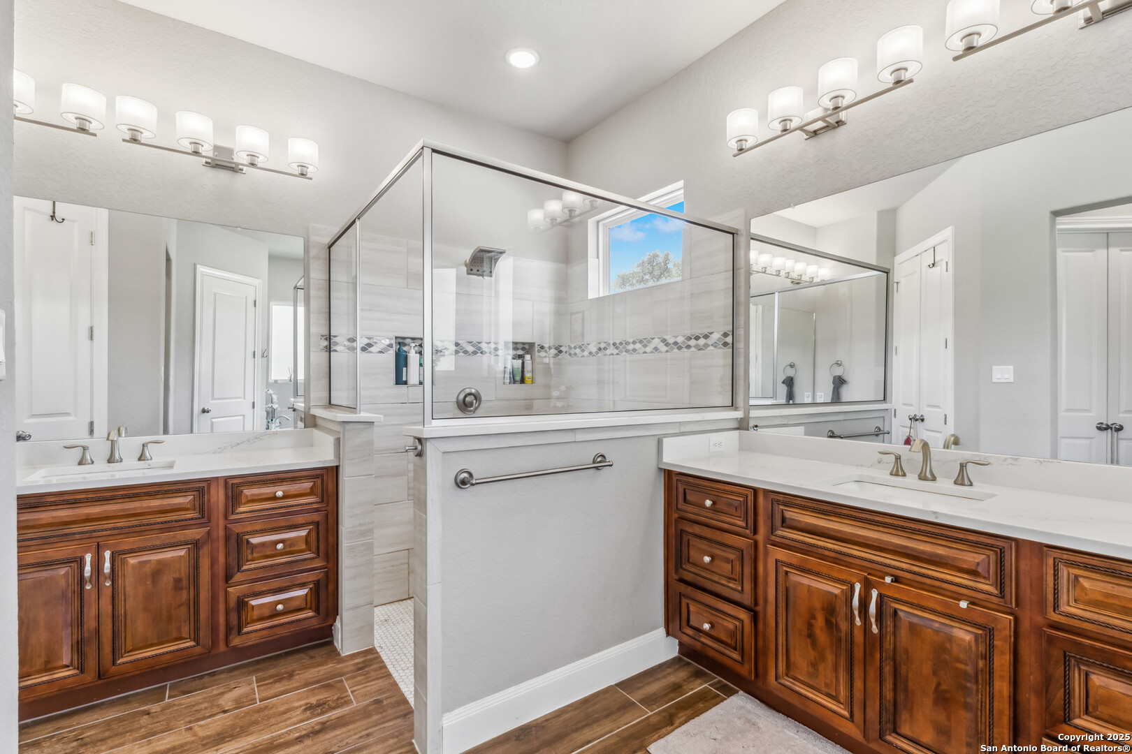 2319 Cascada Parkway Spring Branch, TX 78070 - Photo 18 of 32 a spacious bathroom with double vanity a mirror a vanity and a shower