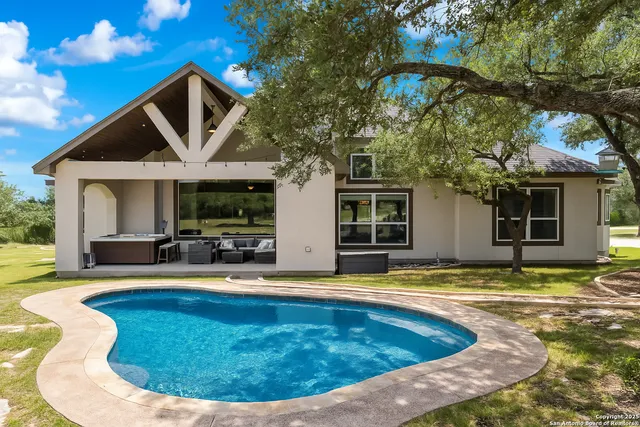 a view of a house with swimming pool and sitting area