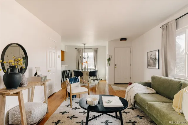 a living room with furniture a rug a lamp and a window