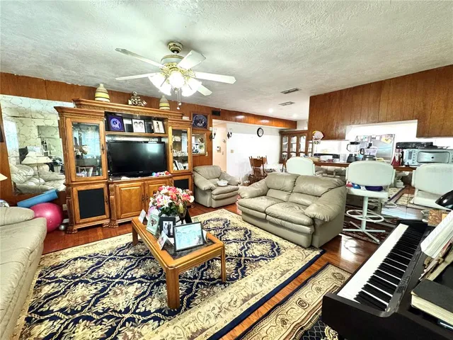 a living room with furniture a flat screen tv and a dining table