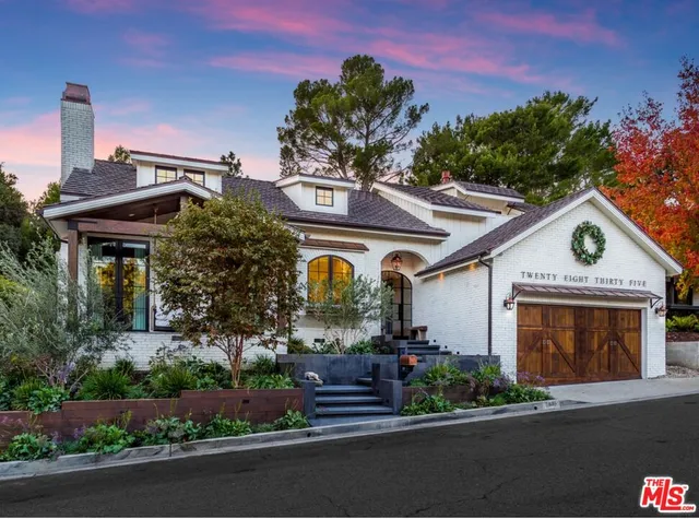 a front view of a house with a garden