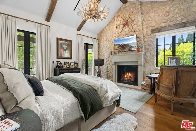 a spacious bedroom with a balcony a bed and a fireplace