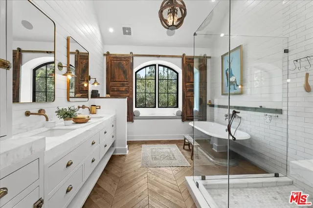 a bathroom with a granite countertop sink a mirror and a bathtub