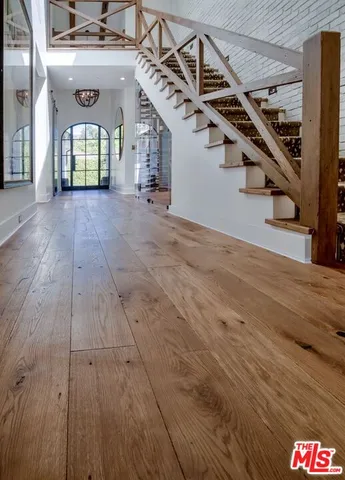 a view of a hallway with wooden floors and stairs