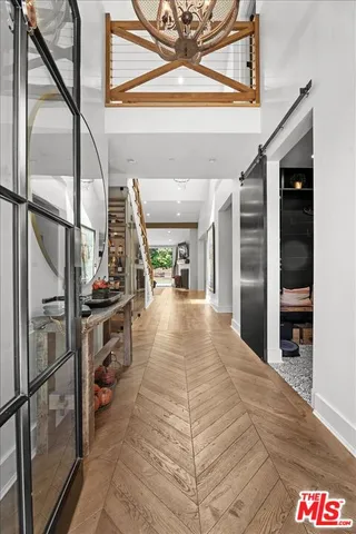 a view of a hallway with wooden floor and staircase