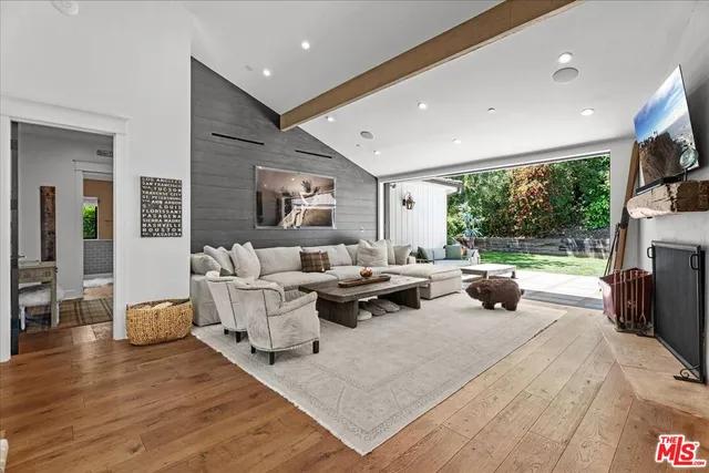 a living room with fireplace furniture and a large window