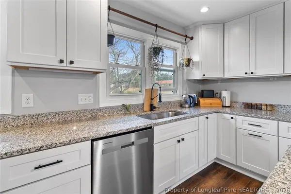 a kitchen with granite countertop white cabinets and white appliances