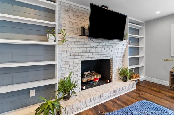 a living room with furniture a flat screen tv a lamp and a fireplace