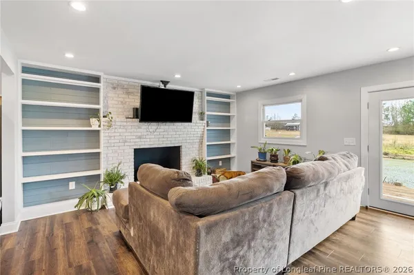 a living room with furniture a flat screen tv and a fireplace
