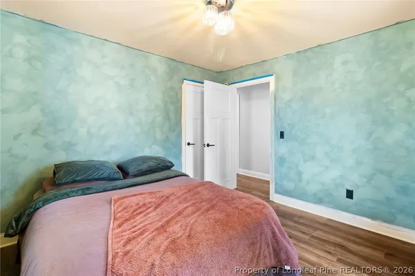 a bedroom with a bed and a chandelier fan