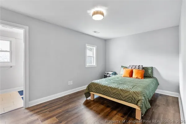 a bedroom with a bed and wooden floor
