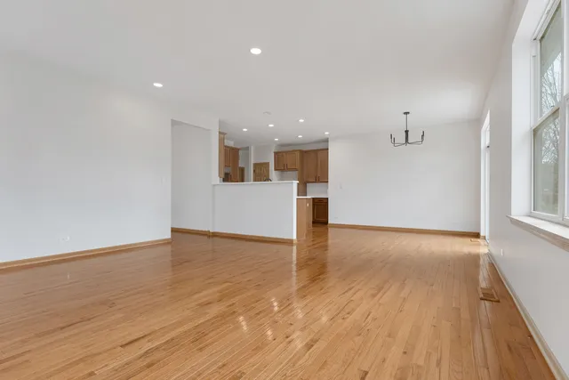 a view of empty room with wooden floor and window