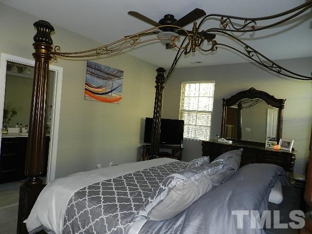 688 Wickham Ridge Road Apex, NC 27539 - Photo 13 of 20 a bedroom with a bed and a mirror on the dresser