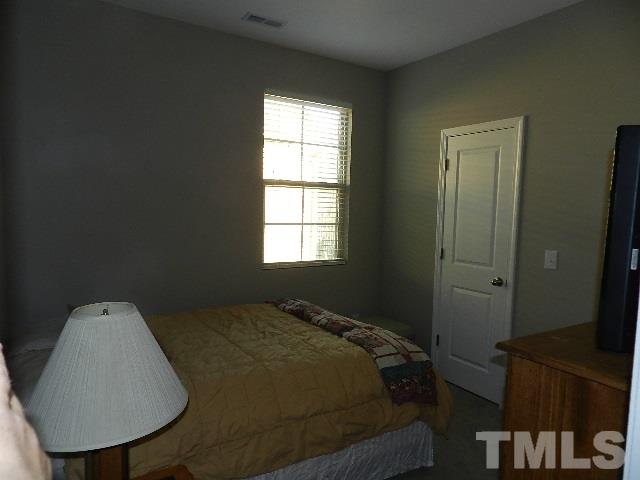 688 Wickham Ridge Road Apex, NC 27539 - Photo 16 of 20 a bed sitting in a bedroom next to a window