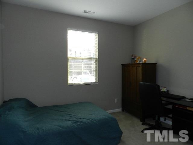 688 Wickham Ridge Road Apex, NC 27539 - Photo 18 of 20 a bed sitting in a bedroom next to a window