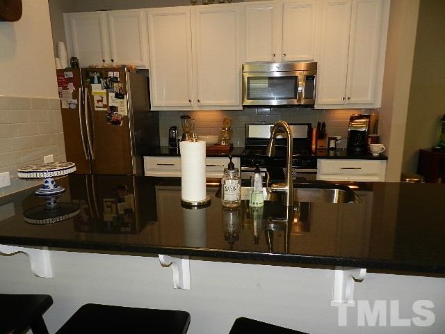 688 Wickham Ridge Road Apex, NC 27539 - Photo 4 of 20 a kitchen with a refrigerator and a stove