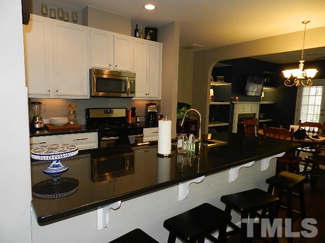 688 Wickham Ridge Road Apex, NC 27539 - Photo 5 of 20 a kitchen with a stove and a microwave