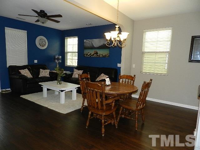 688 Wickham Ridge Road Apex, NC 27539 - Photo 8 of 20 a view of a dining room with furniture a chandelier and wooden floor