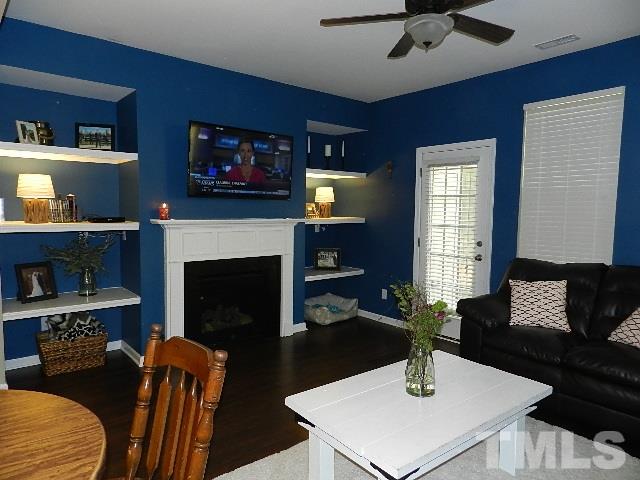 688 Wickham Ridge Road Apex, NC 27539 - Photo 10 of 20 a living room with furniture a fireplace and a flat screen tv