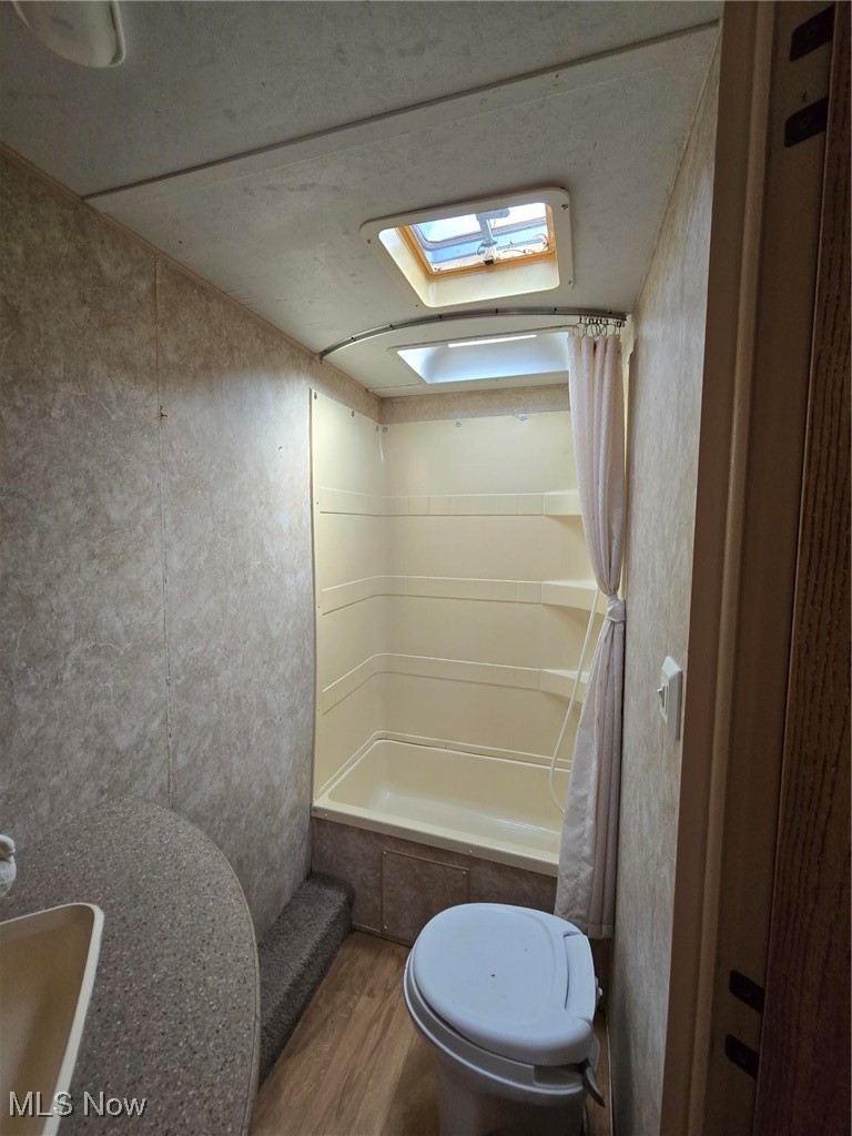 Hill Road Malta, OH 43758 - Photo 11 of 12 Bathroom featuring a skylight, curtained shower, and wood finished floors