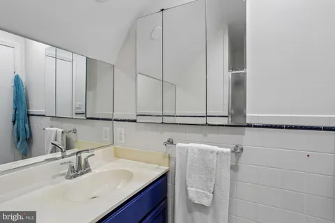 a bathroom with a granite countertop shower sink and mirror