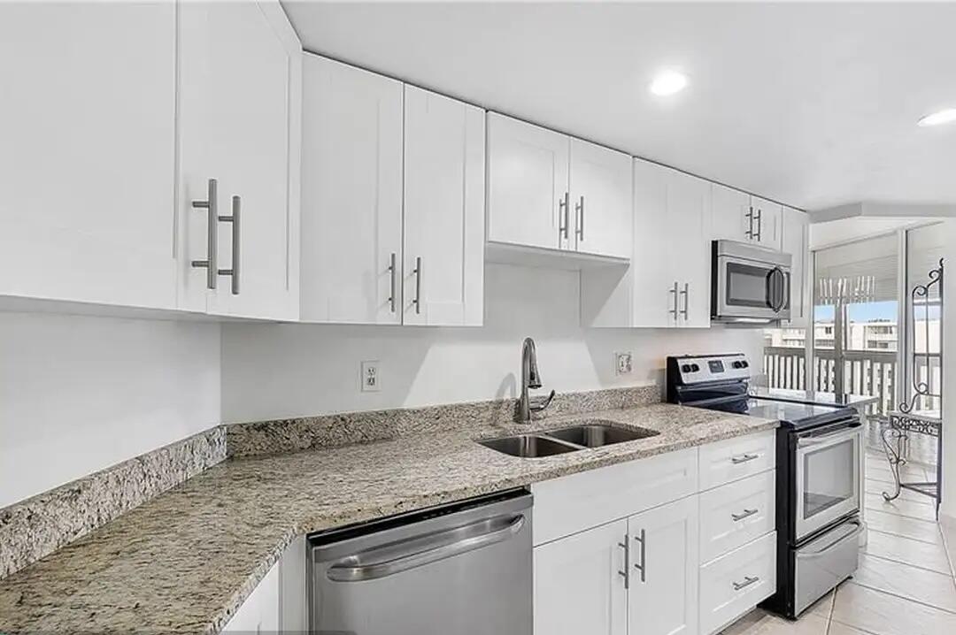 6921 Environ Boulevard, Unit 6S Lauderhill, FL 33319 - Photo 5 of 9 a kitchen with stainless steel appliances granite countertop a sink a stove and cabinets