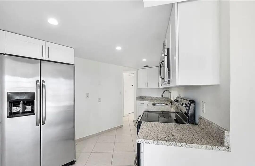 6921 Environ Boulevard, Unit 6S Lauderhill, FL 33319 - Photo 9 of 9 a kitchen with a refrigerator a sink a counter top space and cabinets