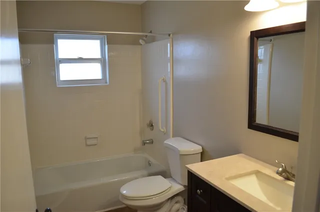 a bathroom with a sink toilet vanity and shower