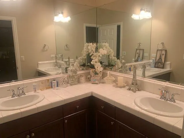 a bathroom with double vanity sinks and a mirror