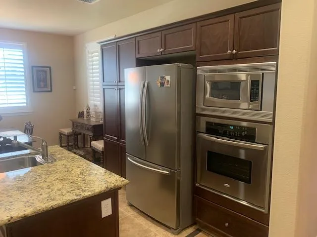 a kitchen with granite countertop a refrigerator stove and sink