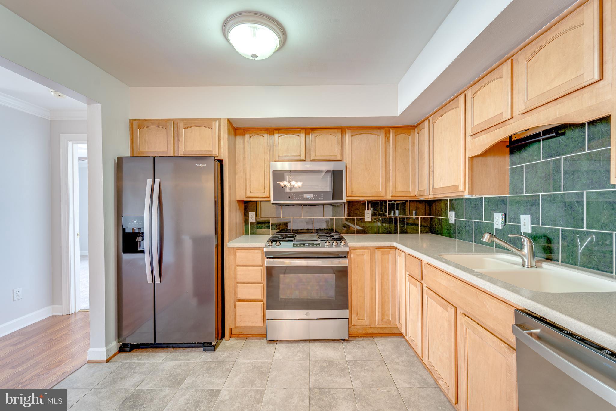 9220 Cardinal Forest Lane, Unit E Lorton, VA 22079 - Photo 11 of 26 a kitchen with stainless steel appliances granite countertop a refrigerator and a sink