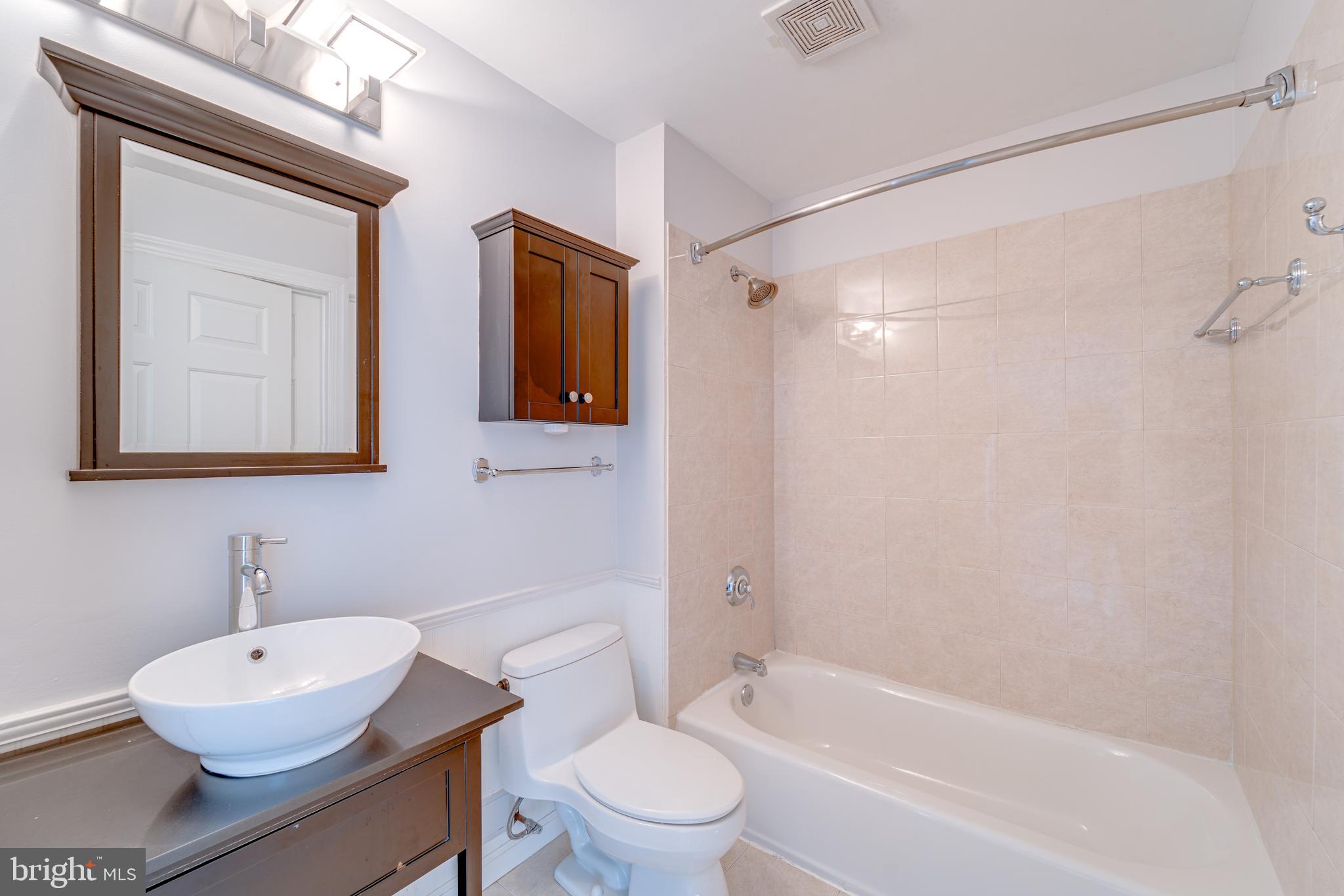 9220 Cardinal Forest Lane, Unit E Lorton, VA 22079 - Photo 17 of 26 a bathroom with a sink toilet a mirror and shower