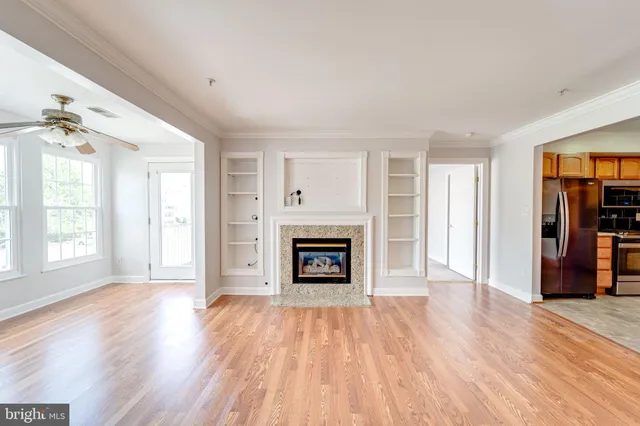 an empty room with windows and a fireplace