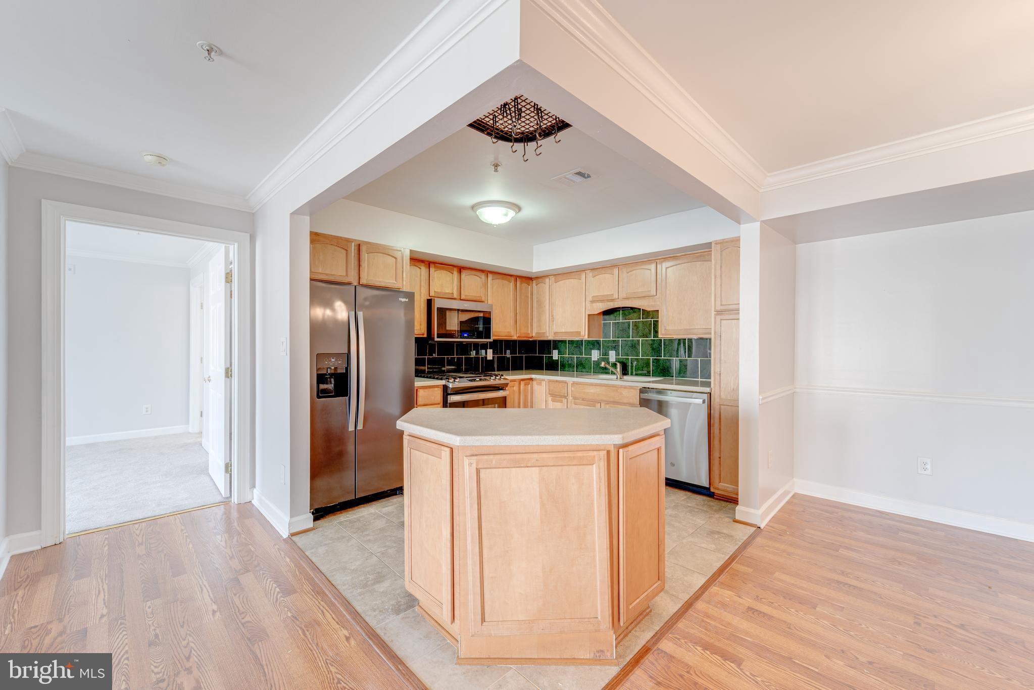 9220 Cardinal Forest Lane, Unit E Lorton, VA 22079 - Photo 9 of 26 a kitchen with stainless steel appliances granite countertop a refrigerator a stove a sink and white cabinets with wooden floor