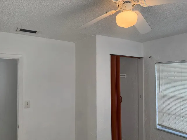 a bathroom with a shower and a ceiling fan