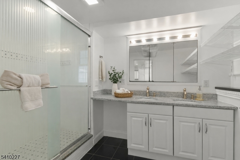 444 White Oak Ridge Road Short Hills, NJ 07078 - Photo 13 of 17 a bathroom with a granite countertop sink a mirror and a shower