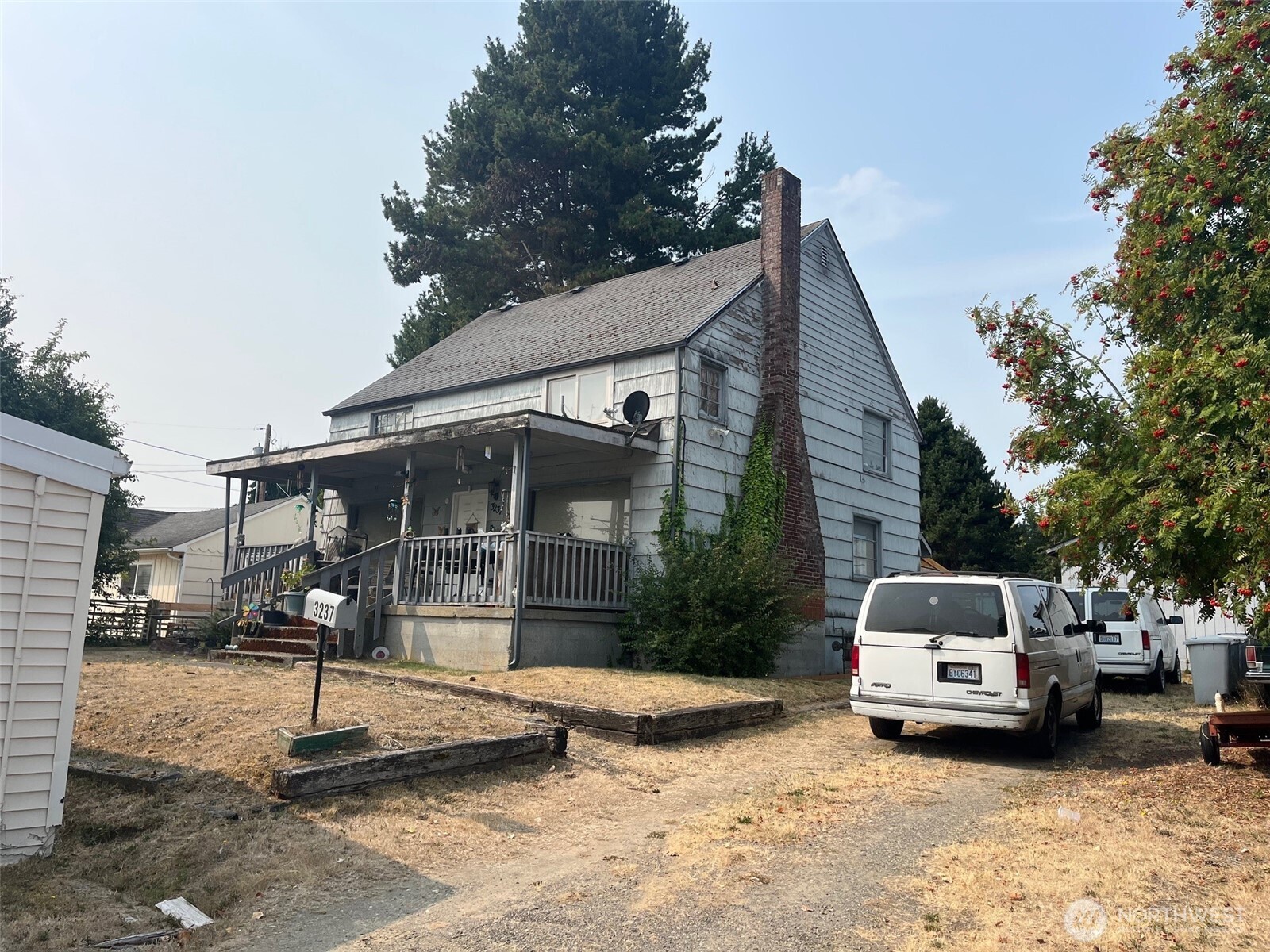 a front view of a house with cars parked