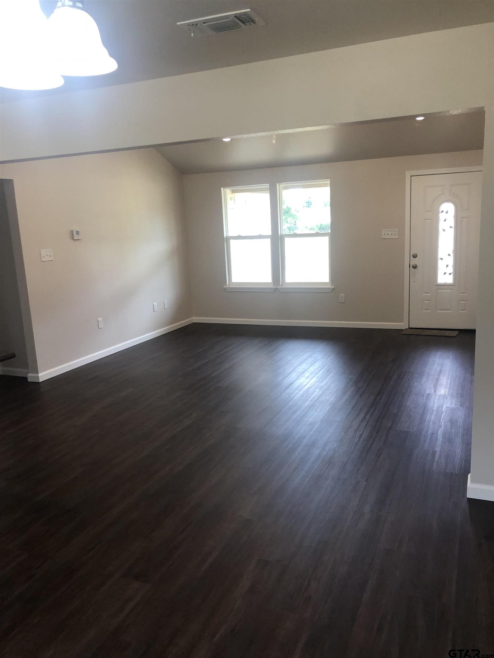 107 Meadow Lane Naples, TX 75568 - Photo 6 of 16 an empty room with wooden floor and windows