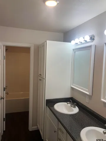 a bathroom with a granite countertop sink and a mirror