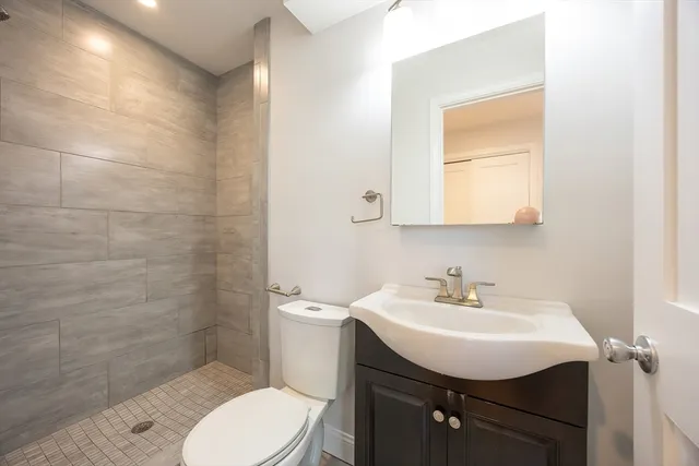 a bathroom with a sink toilet and mirror