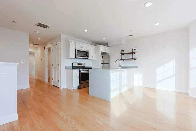 a large kitchen with cabinets and stainless steel appliances