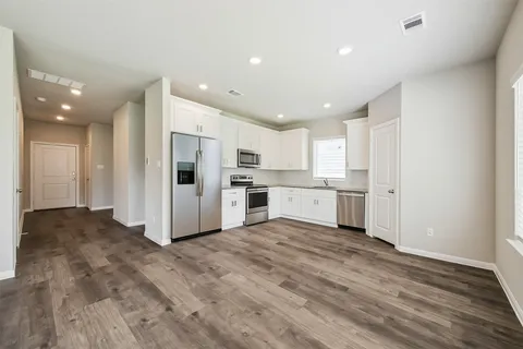 a view of a kitchen with a sink and dishwasher a refrigerator with wooden floor