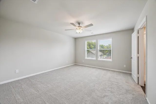 an empty room with a window and a ceiling fan