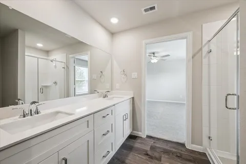 a spacious bathroom with a double vanity sink mirror and shower