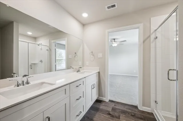 a spacious bathroom with a double vanity sink mirror and shower