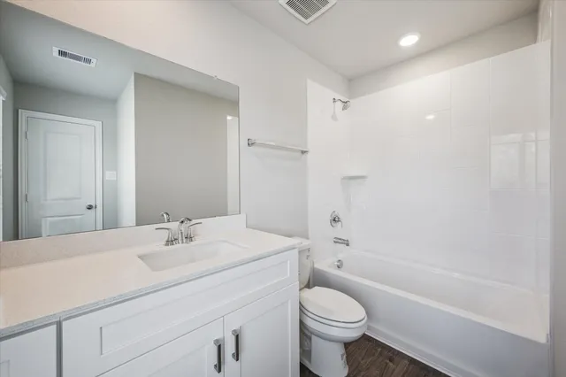a bathroom with a sink a toilet and a large mirror