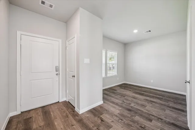 wooden floor in an empty room with a window