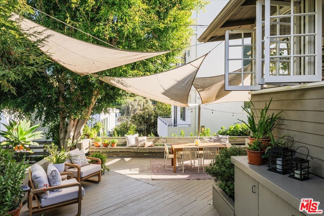 2315 Cove Avenue Los Angeles, CA 90039 - Photo 27 of 49 a view of a patio with table and chairs potted plants with palm trees